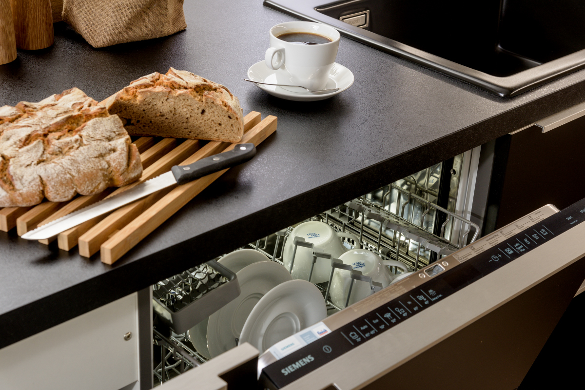 Geöffneter eingebauter Geschirrspüler von Siemens in Küchenzeile mit Granitarbeitsplatte